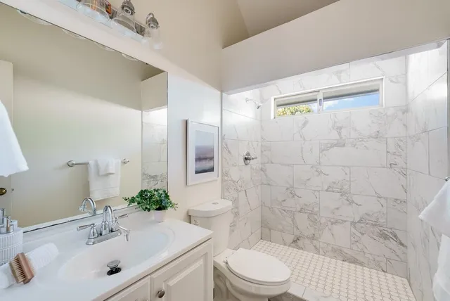 a bathroom with a sink mirror toilet and shower