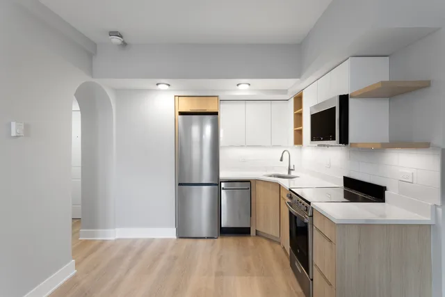 a kitchen with a sink a refrigerator and a stove top oven