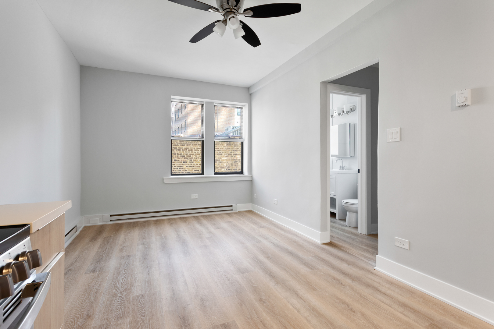 1634 West Howard Street, Unit 309 Chicago, IL 60626 - Photo 7 of 9 an empty room with wooden floor cabinet and windows