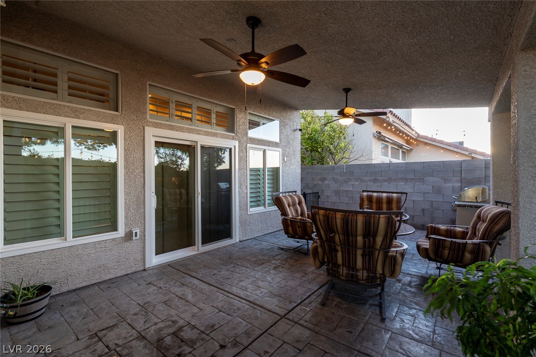 818 Manor Shores Road Henderson, NV 89002 - Photo 29 of 35 An inviting covered patio featuring ceiling fans and ample space for outdoor entertaining.