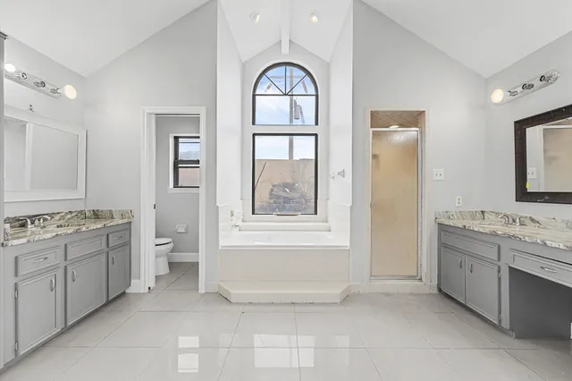 a bathroom with a granite countertop sink a toilet and a bathtub