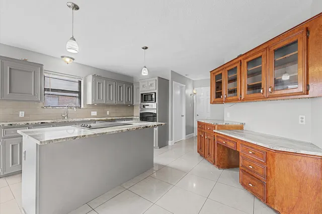 a large kitchen with stainless steel appliances granite countertop a stove a sink dishwasher and a refrigerator