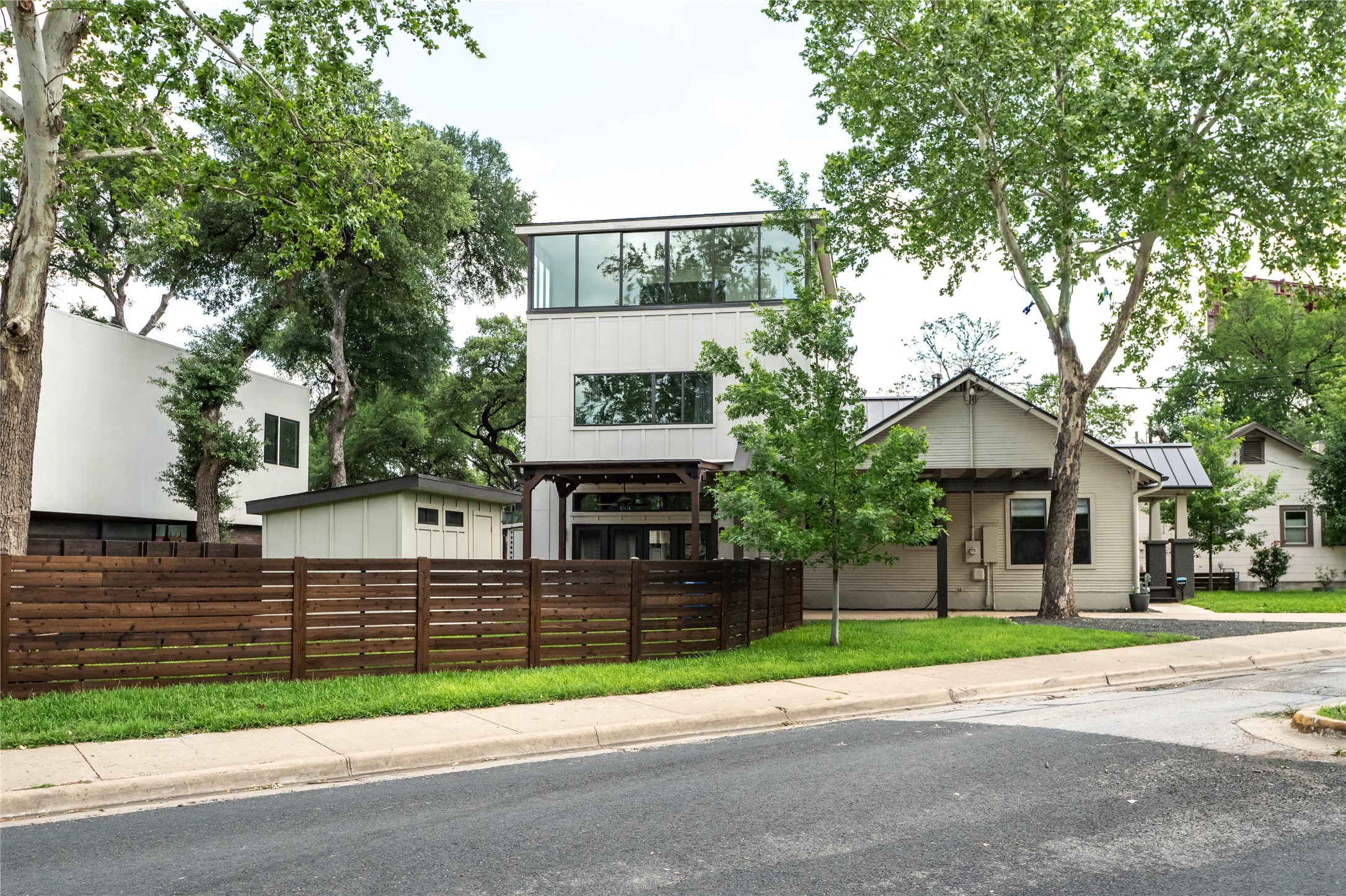 2103 Kinney Avenue Austin, TX 78704 - Photo 1 of 40 Contemporary-style with extensive windows on the upper level, a covered entrance, and a well-maintained lawn, all framed by mature trees