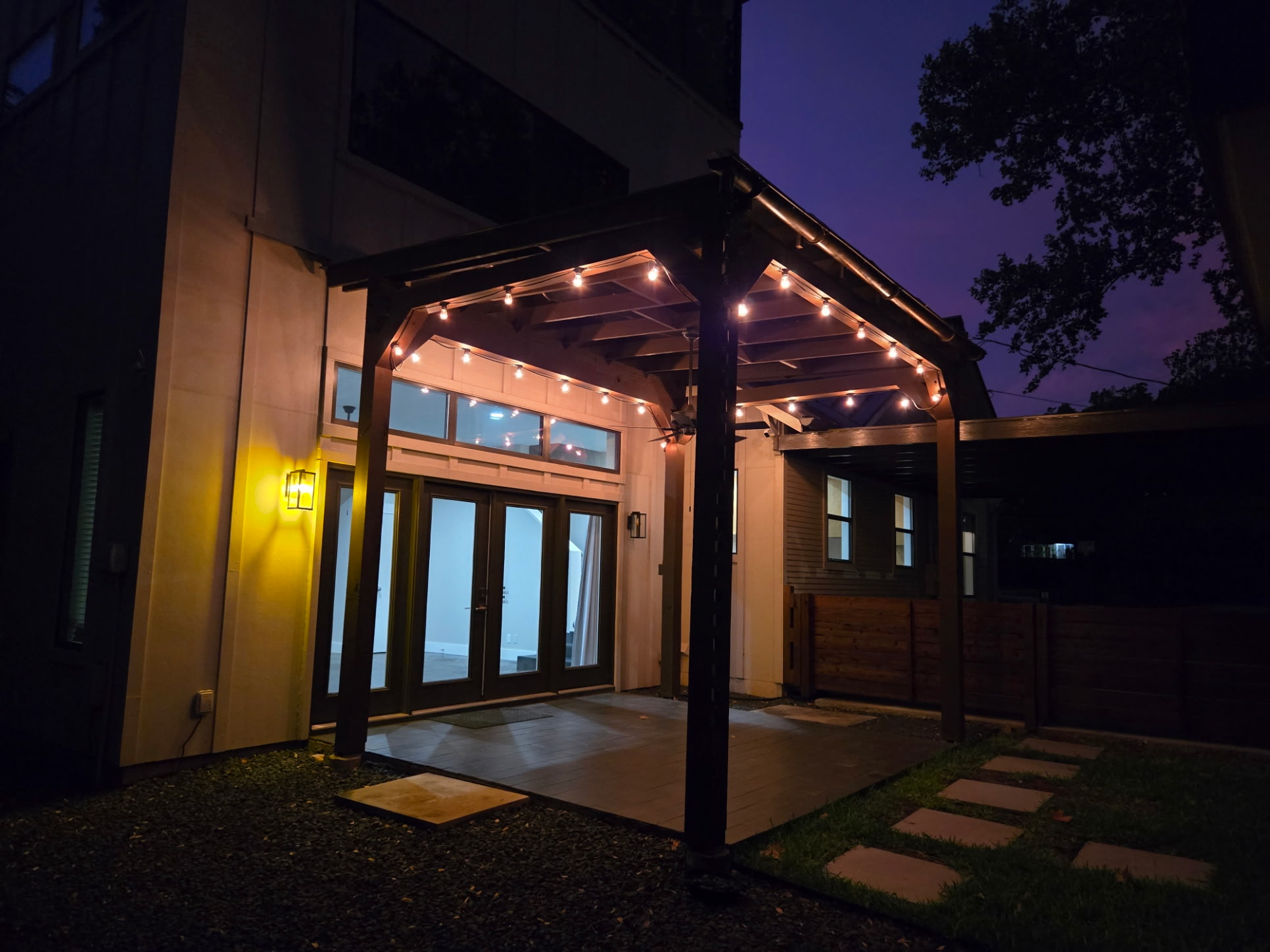 2103 Kinney Avenue Austin, TX 78704 - Photo 12 of 40 Outdoor patio with string lighting, a dark wood pergola, and stepping stones over grass
