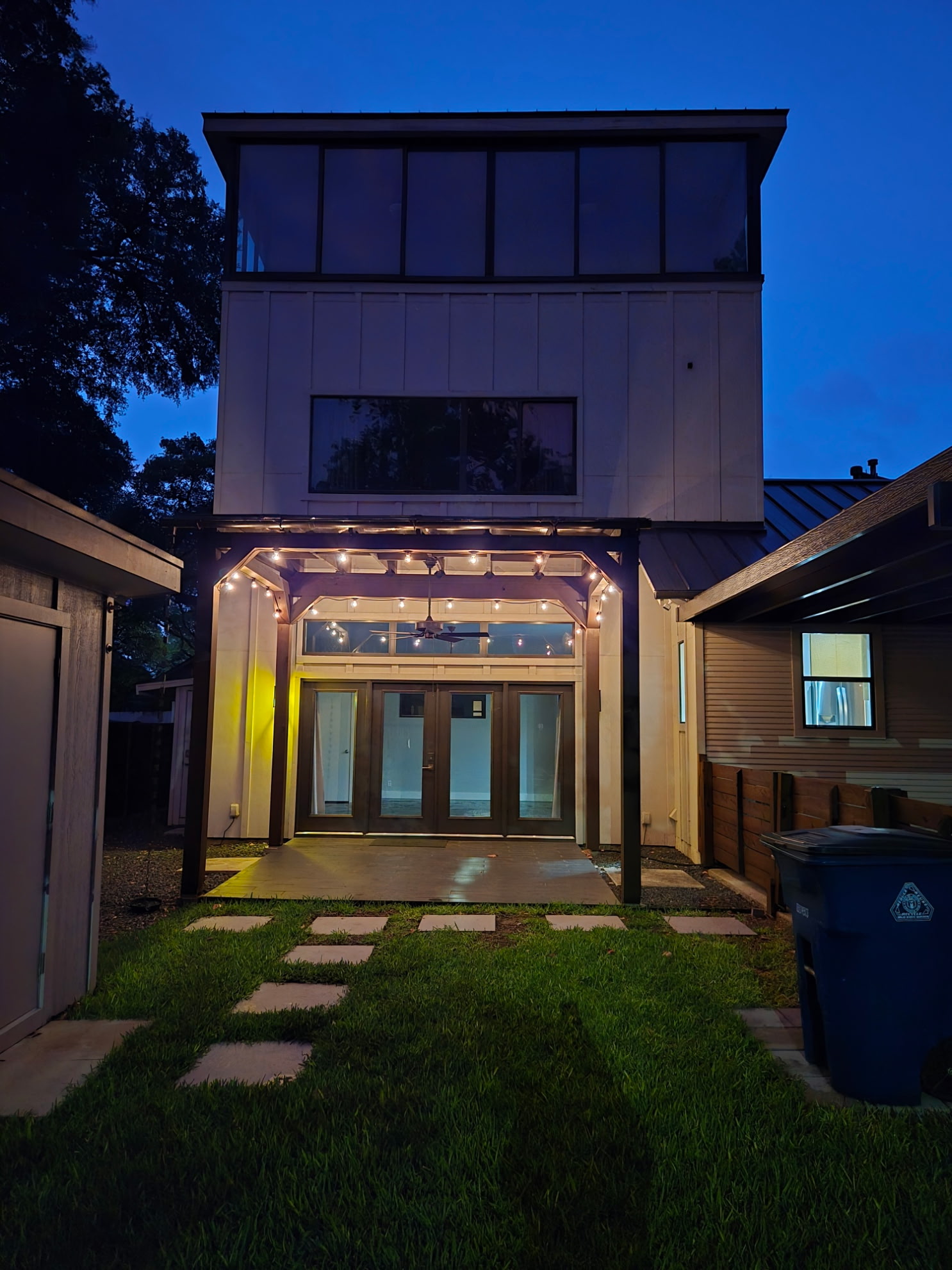 2103 Kinney Avenue Austin, TX 78704 - Photo 13 of 40 Modern exterior with a multi-level design, large windows, and a pergola-covered patio with string lighting