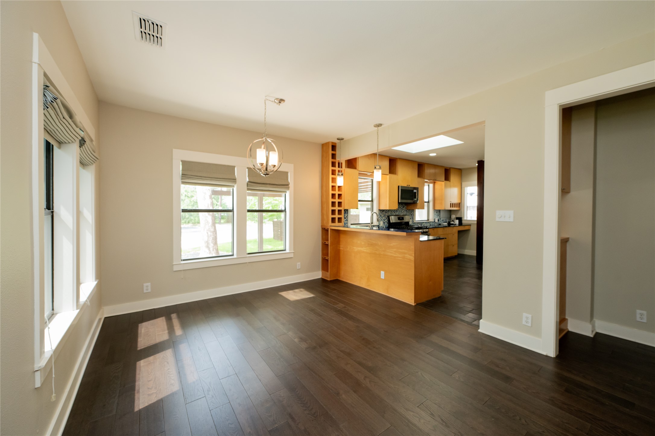 2103 Kinney Avenue Austin, TX 78704 - Photo 18 of 40 Dining area features dark wood flooring, light-colored walls, and large windows that provide natural light