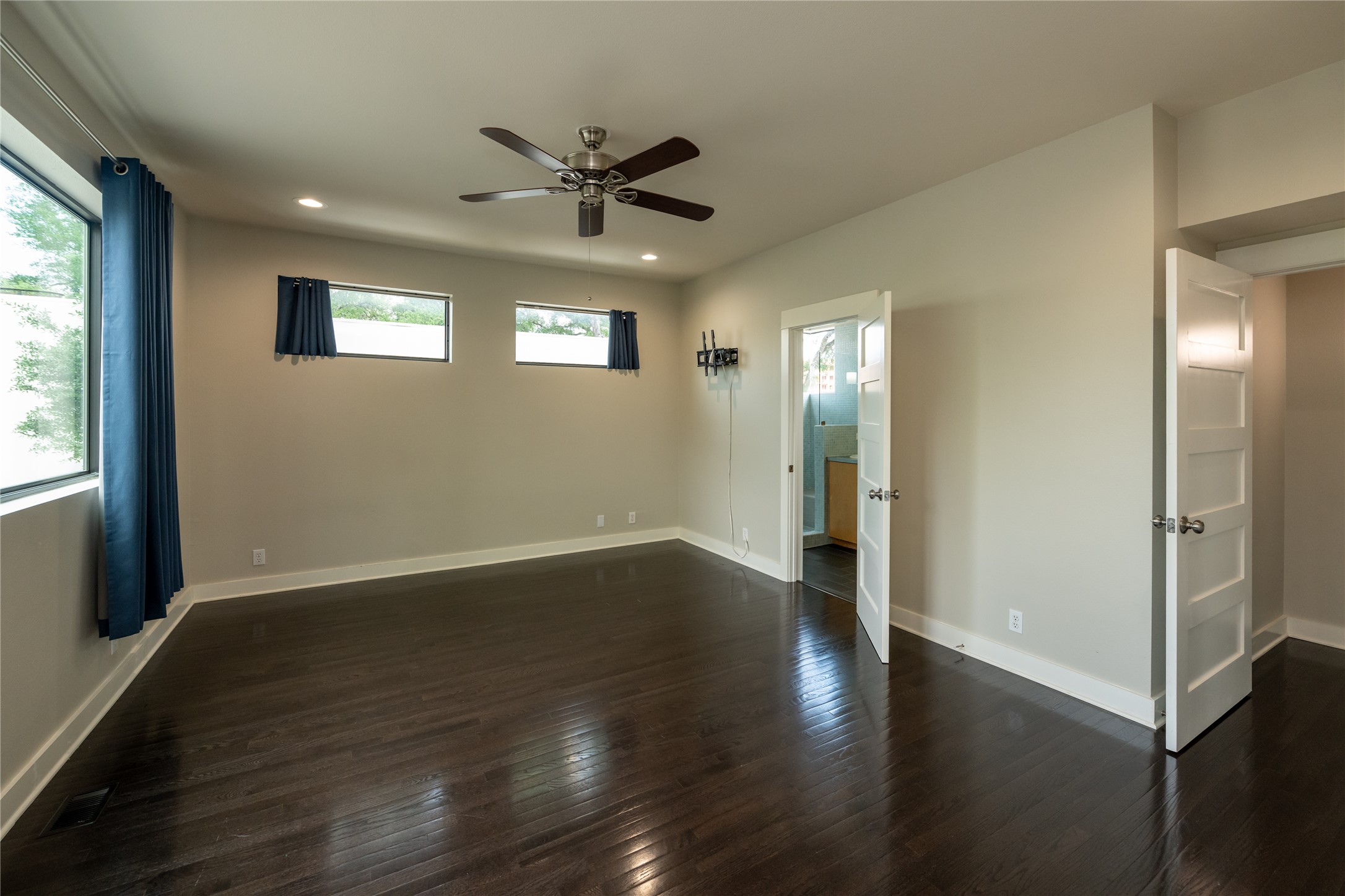 2103 Kinney Avenue Austin, TX 78704 - Photo 25 of 40 This spacious primary bedroom features dark hardwood floors and light-colored walls