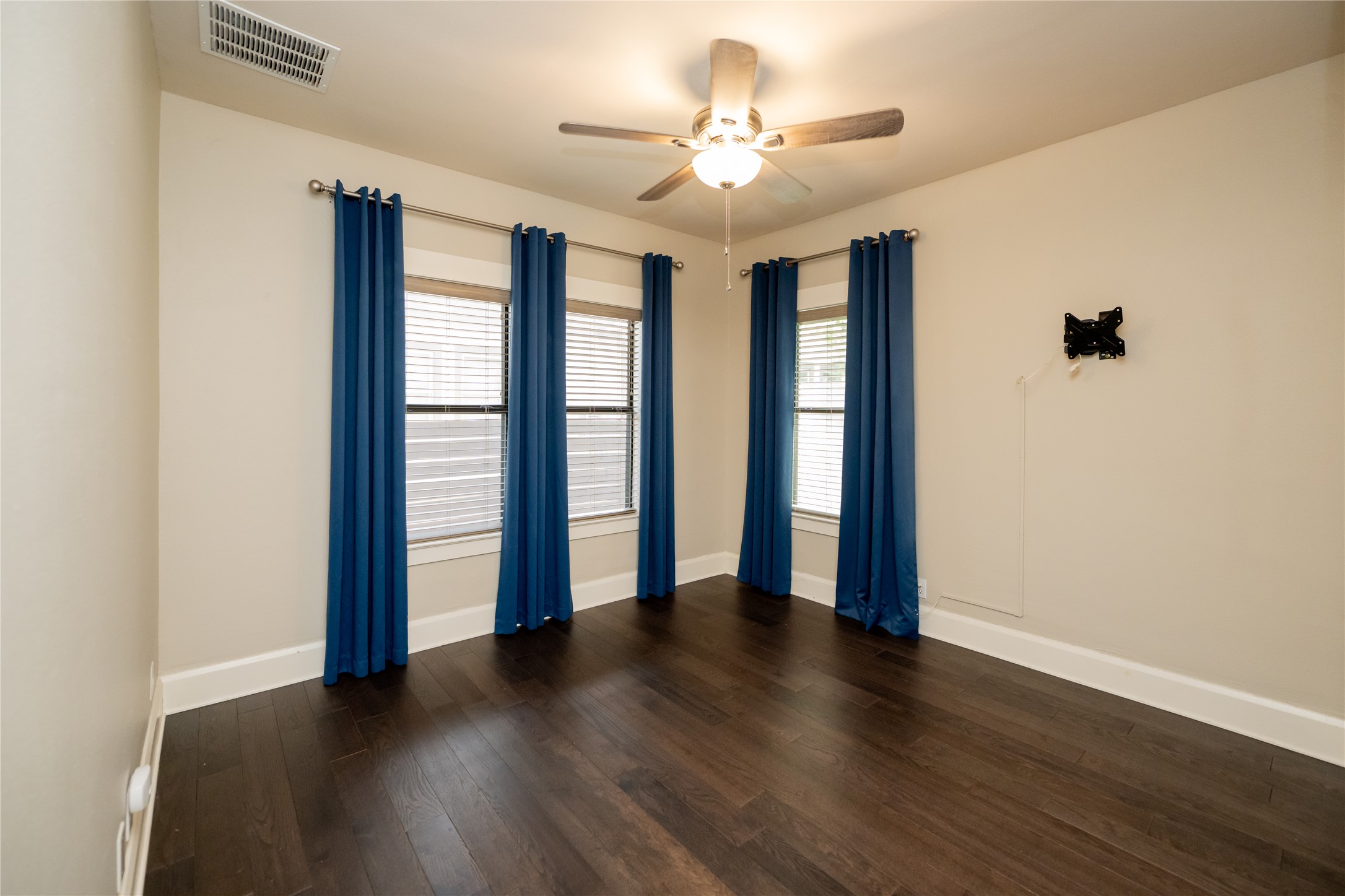 2103 Kinney Avenue Austin, TX 78704 - Photo 30 of 40 This room features dark hardwood flooring, light-colored walls, and a ceiling fan with an integrated light fixture