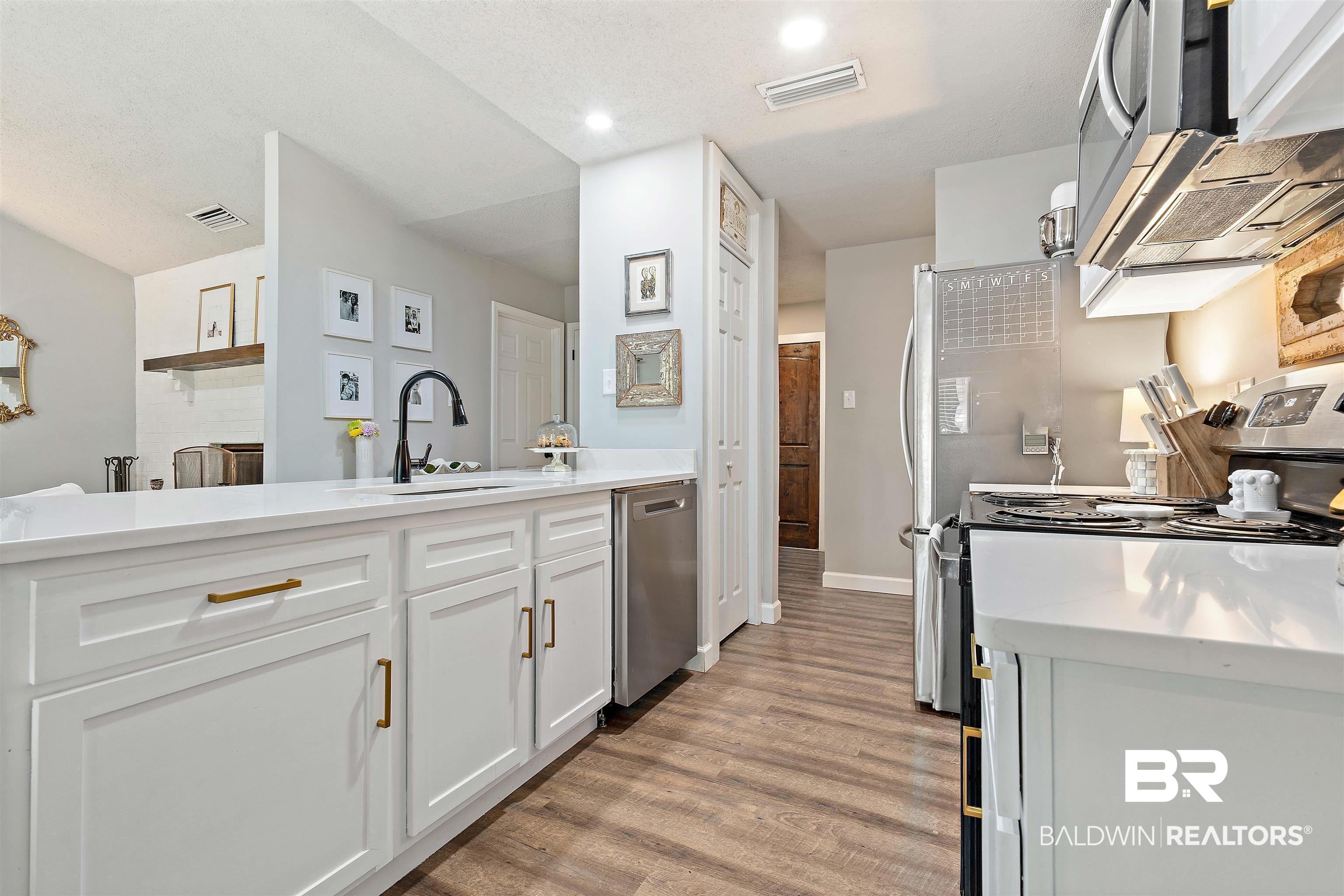 4682 Opal Drive Mobile, AL 36619 - Photo 9 of 27 Kitchen featuring sink, white cabinets, light wood-type flooring, and stainless steel appliances