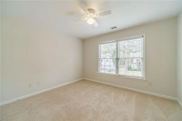 an empty room with a ceiling fan and a window