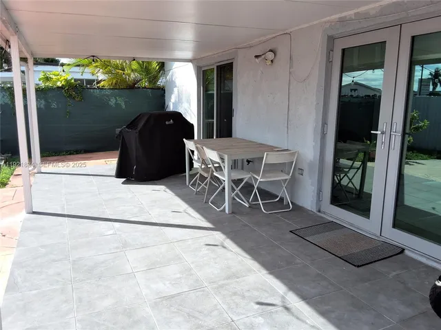 a view of a patio with table and chairs and potted plants