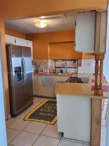 a kitchen with stainless steel appliances granite countertop a refrigerator a stove and a sink