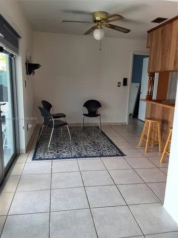 a kitchen with granite countertop a rug a stove a microwave and a dining table