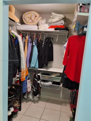 a view of walk in closet with clothes and shoes