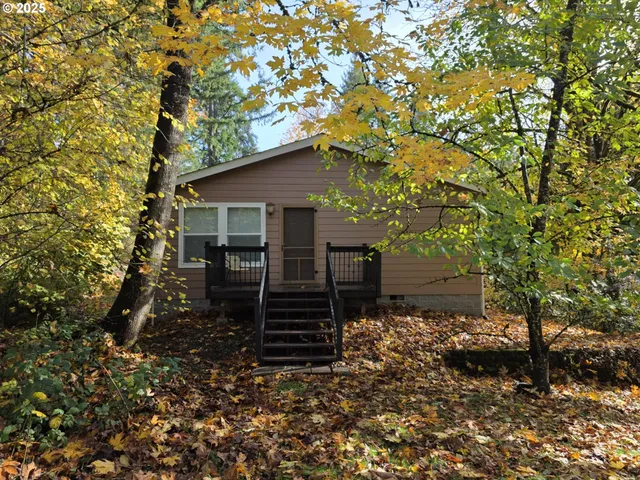a house is sitting in middle of the forest