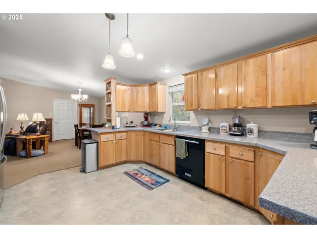 a kitchen with stainless steel appliances kitchen island granite countertop a sink window and cabinets