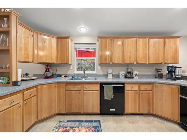 a kitchen with stainless steel appliances granite countertop a stove top oven a sink dishwasher a dining table and chairs with wooden floor