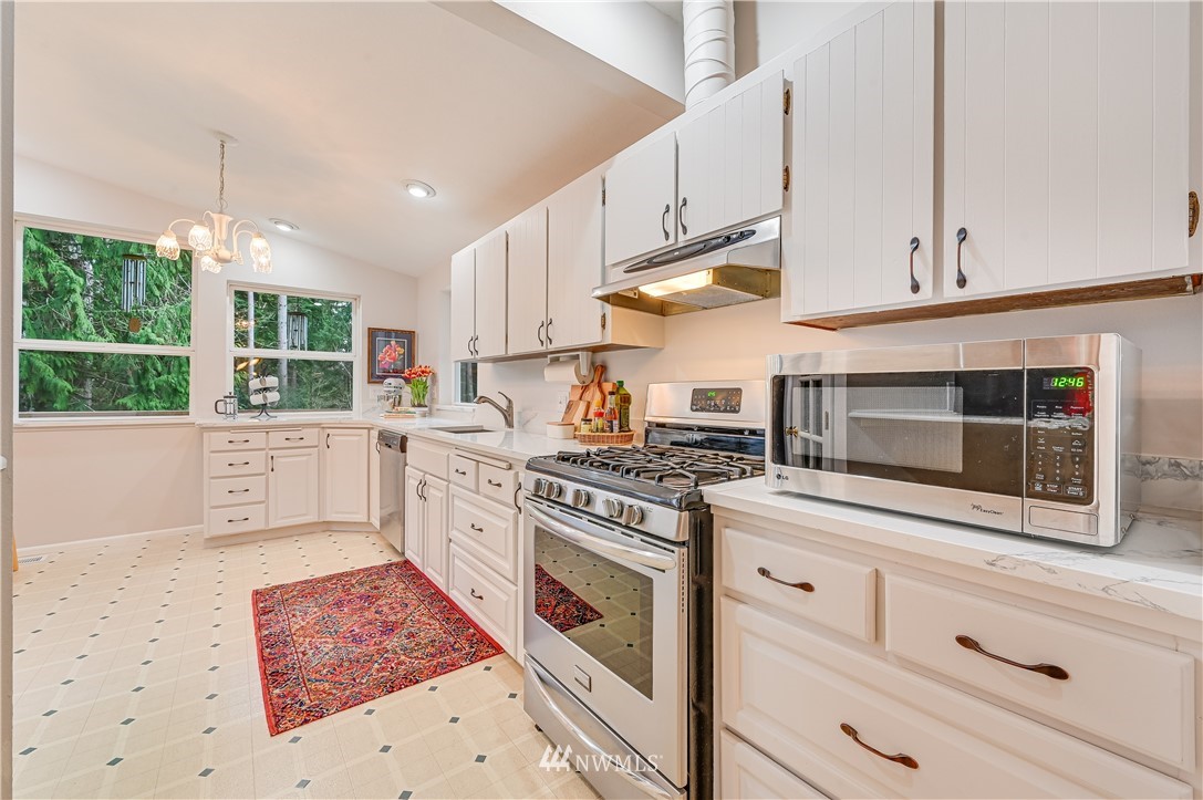 116 East Jonathan Road Bothell, WA 98012 - Photo 7 of 27 a kitchen with stainless steel appliances kitchen island granite countertop a stove a sink and a microwave