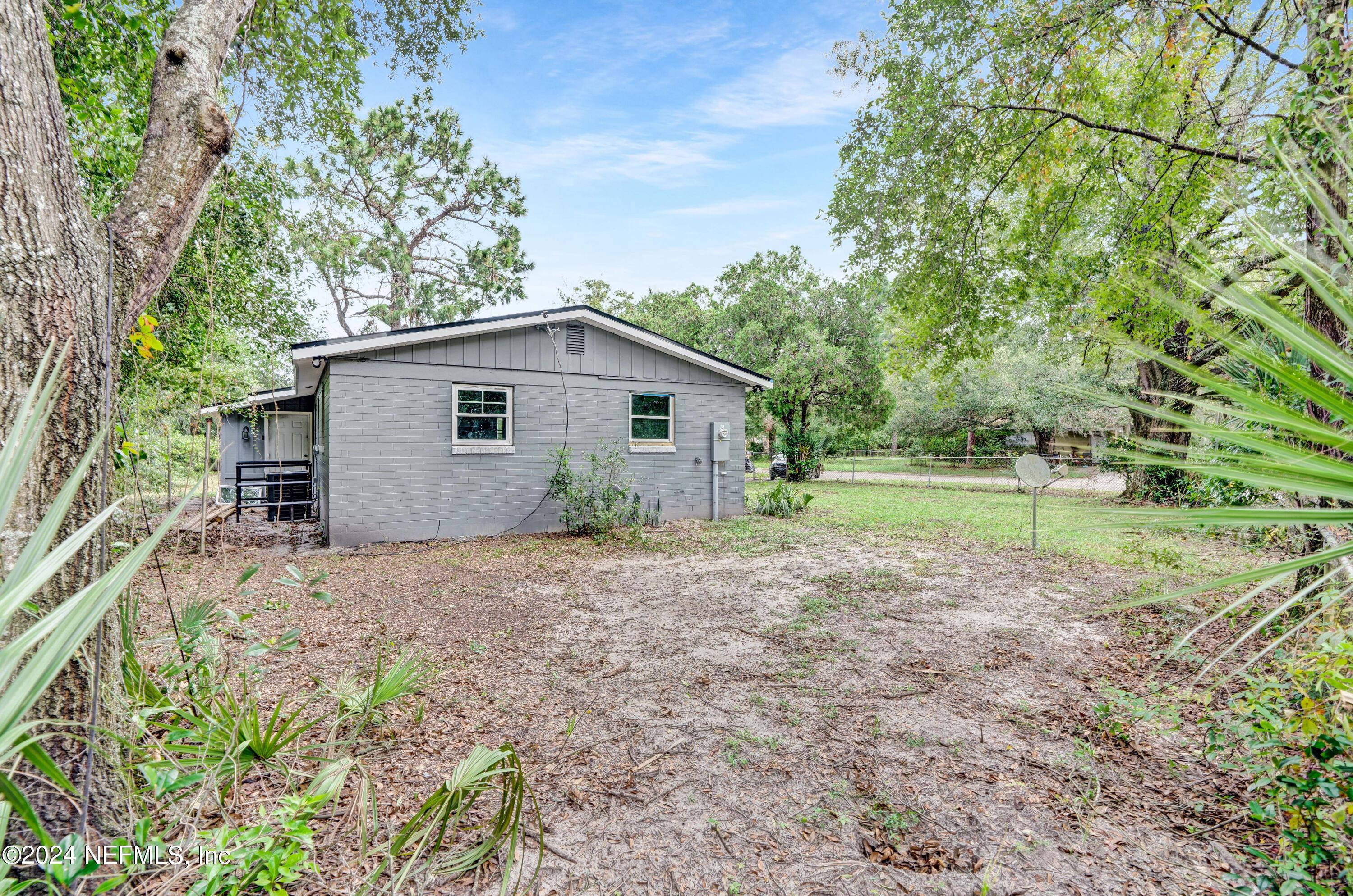 7301 Melvin Road Jacksonville, FL 32210 - Photo 18 of 27 a view of a house with backyard and trees