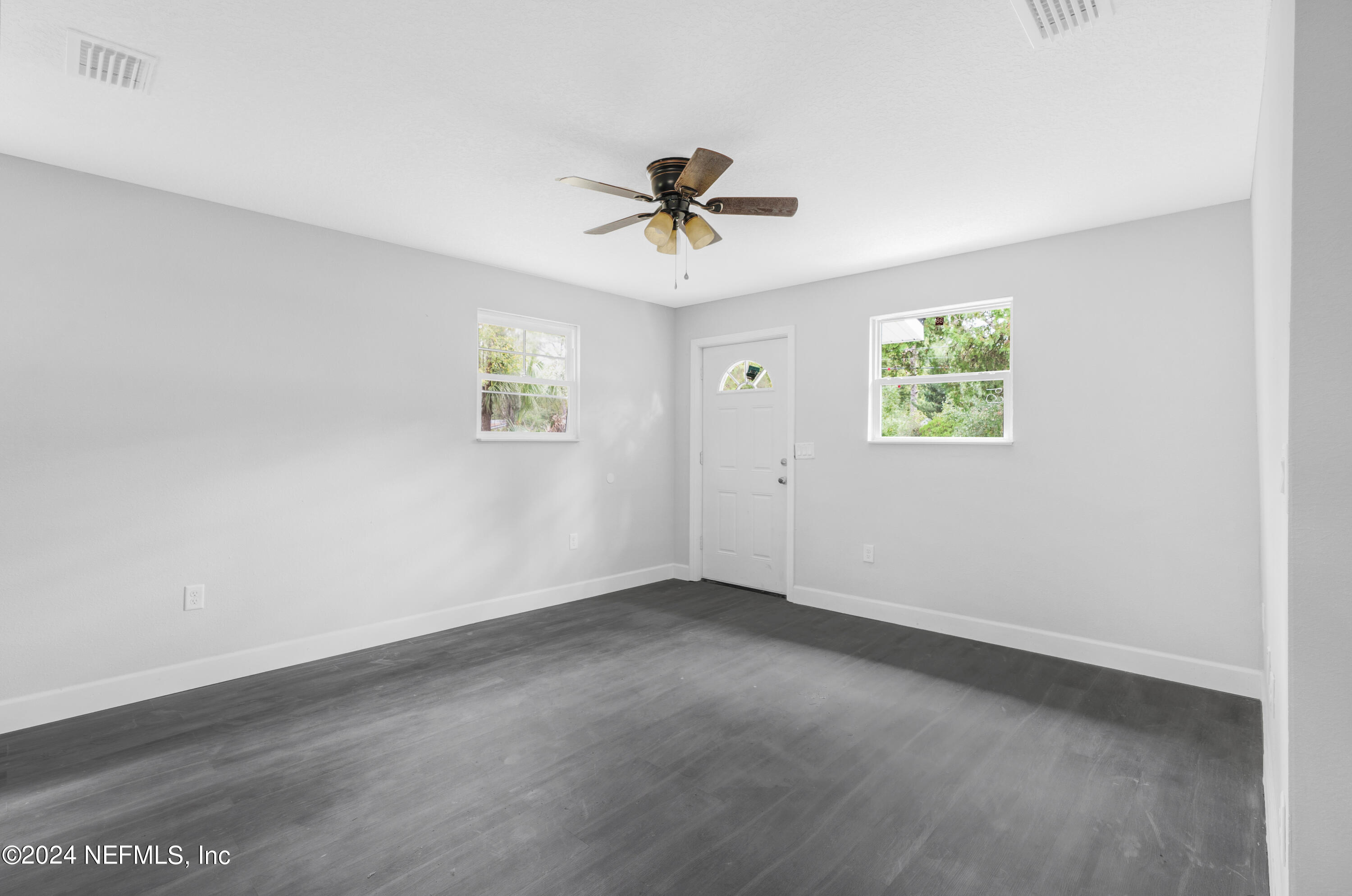 7301 Melvin Road Jacksonville, FL 32210 - Photo 5 of 27 an empty room with windows and fan