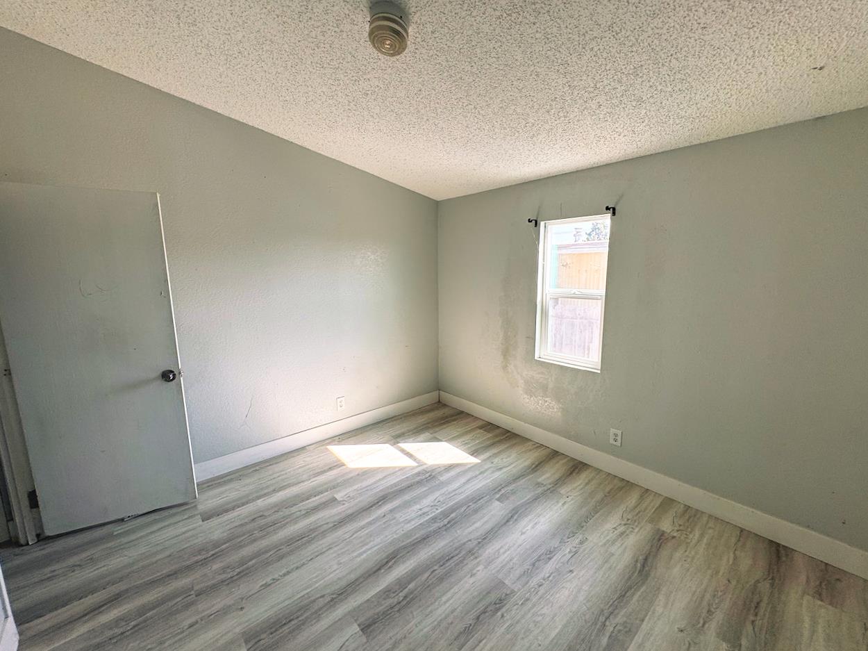 3939 Central Avenue, Unit 35 Ceres, CA 95307 - Photo 25 of 36 an empty room with wooden floor and windows