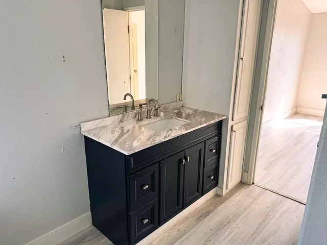 a bathroom with a sink vanity and a mirror