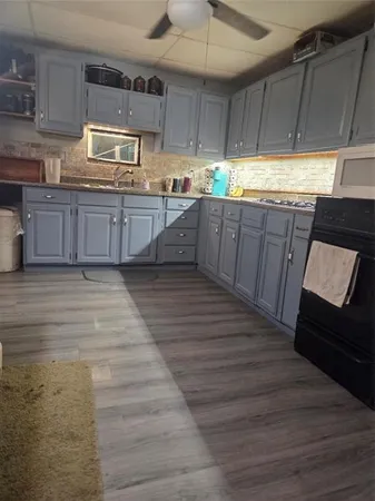a kitchen with wooden floors and wooden cabinets