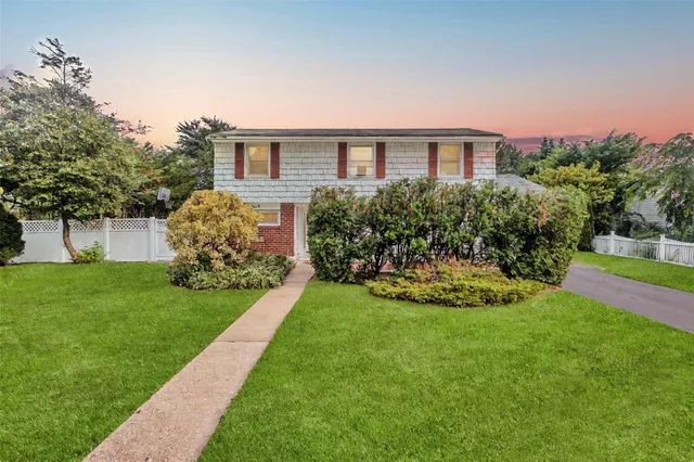 a view of a house with a yard and potted plants