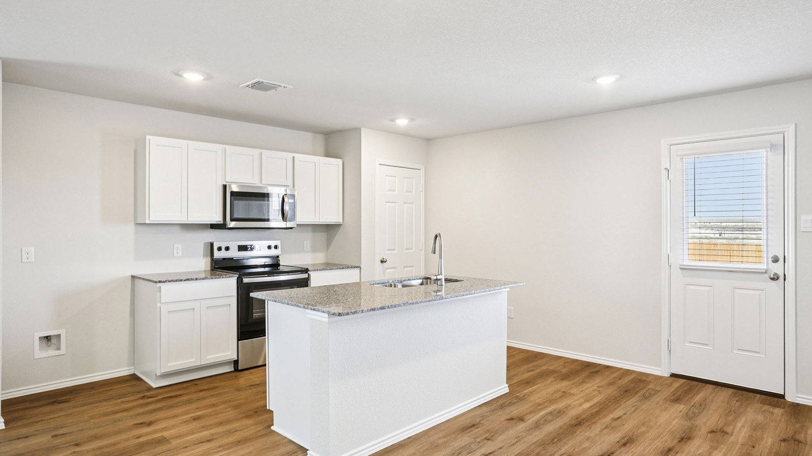 133 Wyatt Way Jarrell, TX 76537 - Photo 2 of 32 Kitchen featuring wood-finish flooring, white cabinetry, granite countertops, a stainless steel microwave, and a stainless steel oven/range