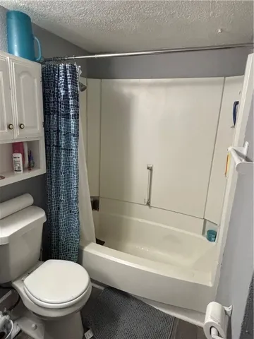 a white toilet sitting next to a bath tub