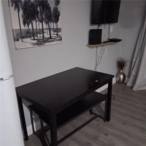 a living room with a table chairs and a flat screen tv