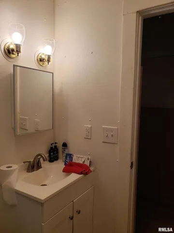 a bathroom with a sink vanity and mirror