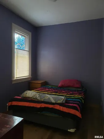 a bed sitting in a bedroom next to a window