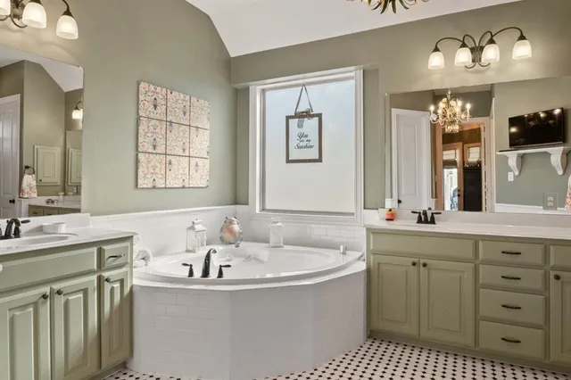 a bathroom with a tub sink and mirror
