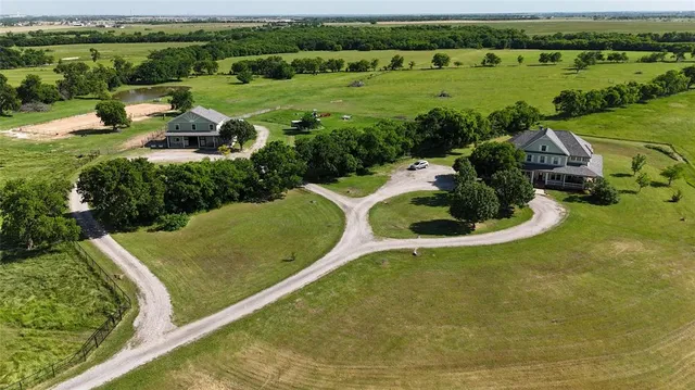 an aerial view of a house with a yard and lake view