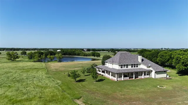 an aerial view of residential houses with outdoor space and trees