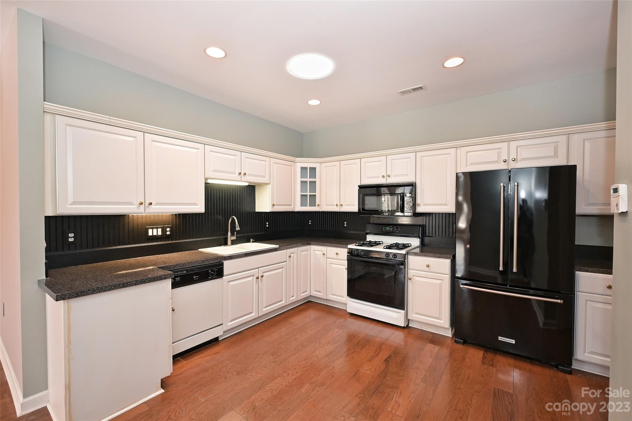 8445 Windsor Ridge Drive Charlotte, NC 28277 - Photo 12 of 26 a kitchen with granite countertop a refrigerator and a stove top oven