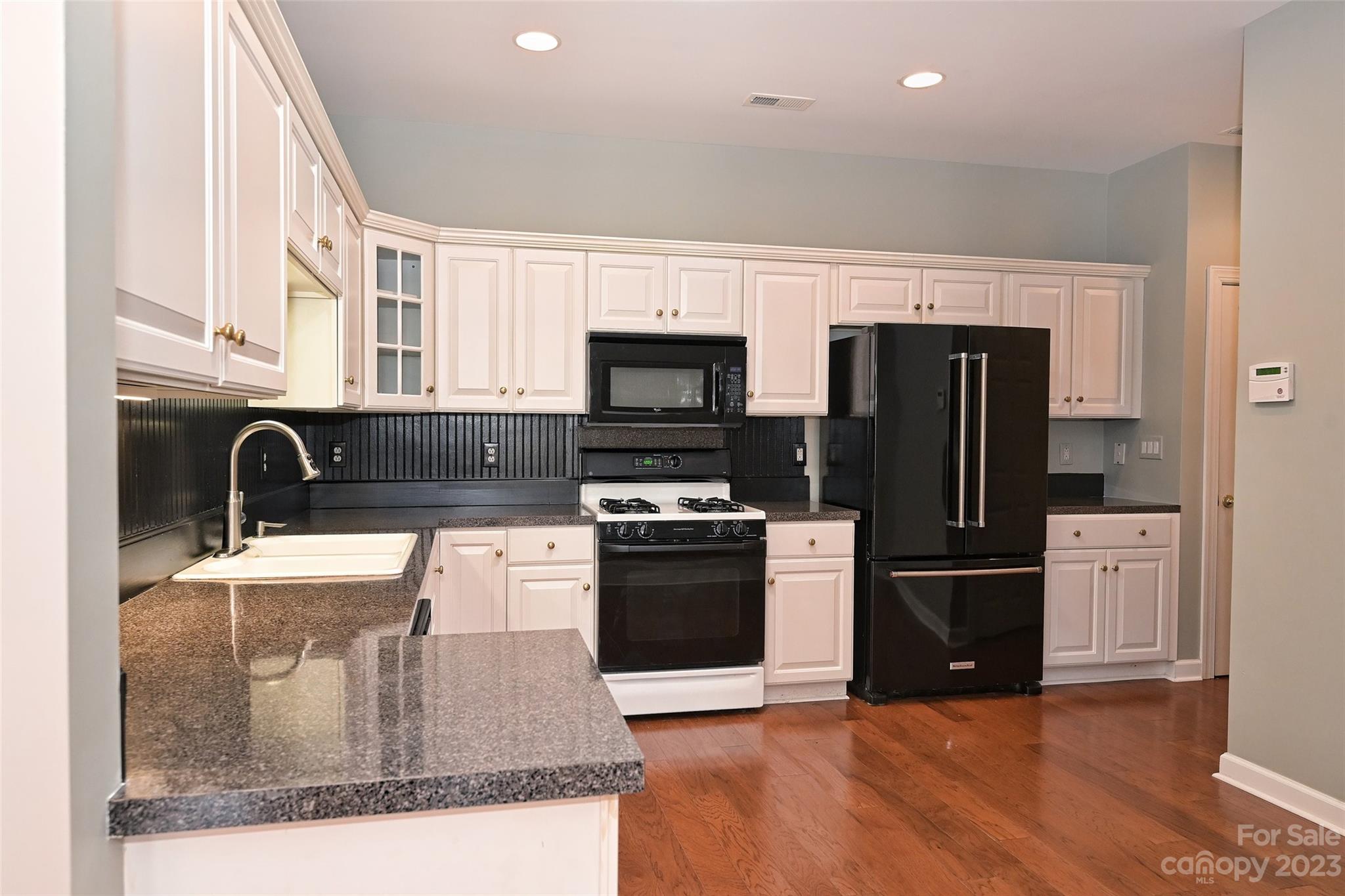 8445 Windsor Ridge Drive Charlotte, NC 28277 - Photo 13 of 26 a kitchen with granite countertop a refrigerator and a sink
