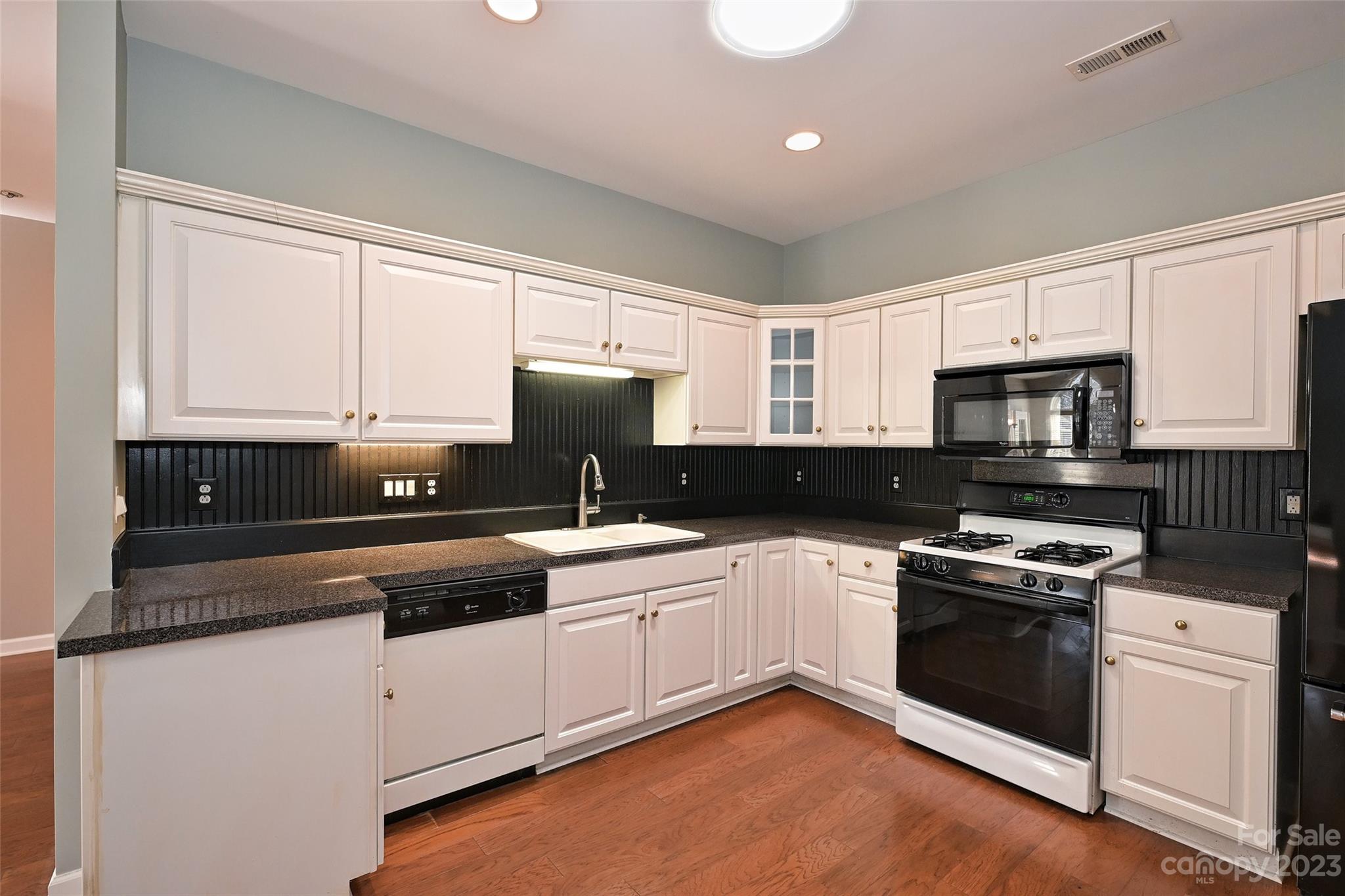8445 Windsor Ridge Drive Charlotte, NC 28277 - Photo 15 of 26 a kitchen with granite countertop white cabinets and white appliances
