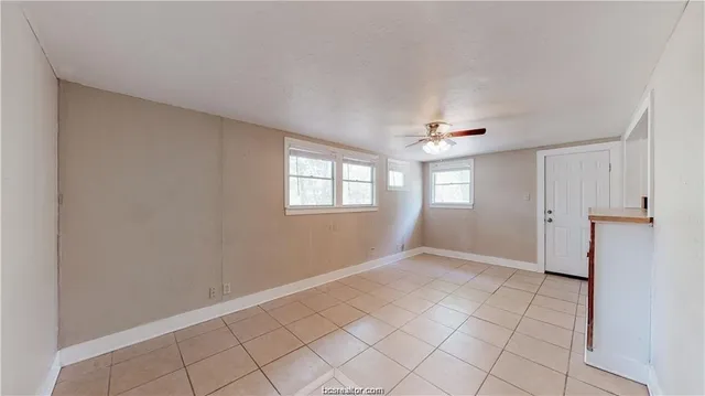 a view of an empty room with window and cabinet