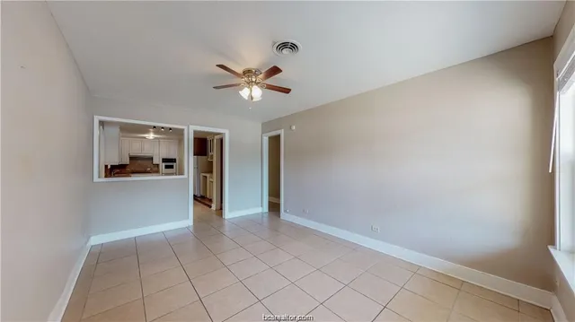 a view of an empty room and kitchen view