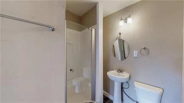 a bathroom with a toilet a sink and mirror