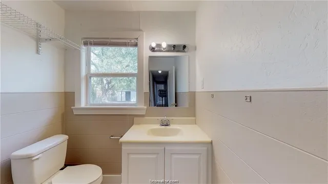 a bathroom with a sink a toilet and a window