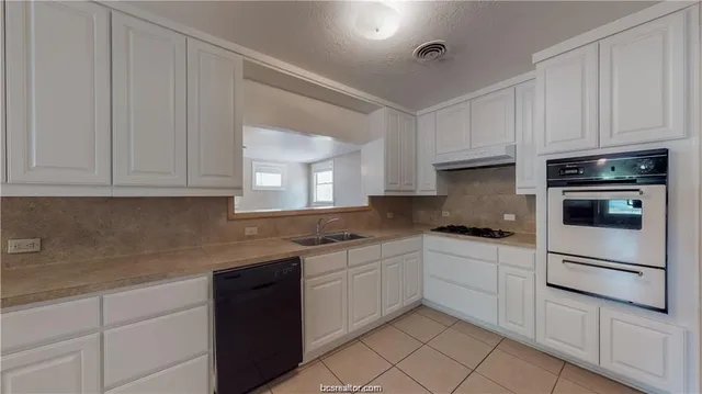 a kitchen with white cabinets and white appliances