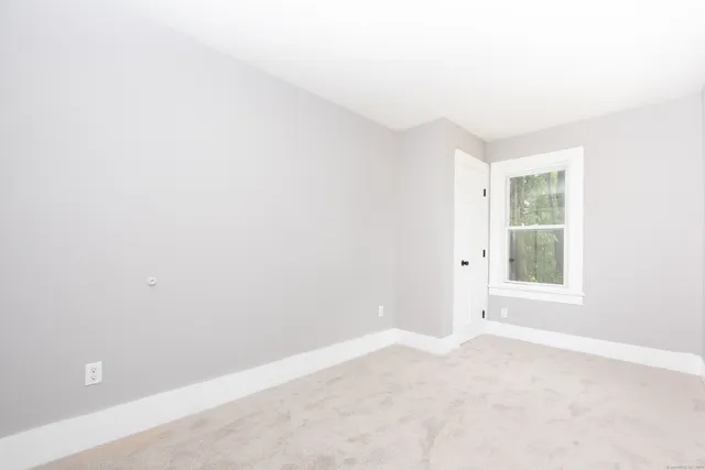a view of a hallway with wooden floor and entryway