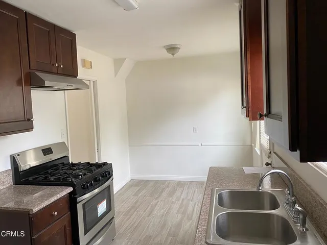 a kitchen with granite countertop a sink stove and cabinets