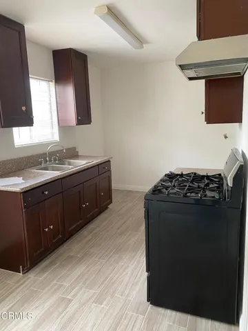 a kitchen with stainless steel appliances a stove a sink and a microwave