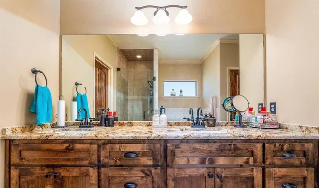 a bathroom with a granite countertop sink and a large mirror