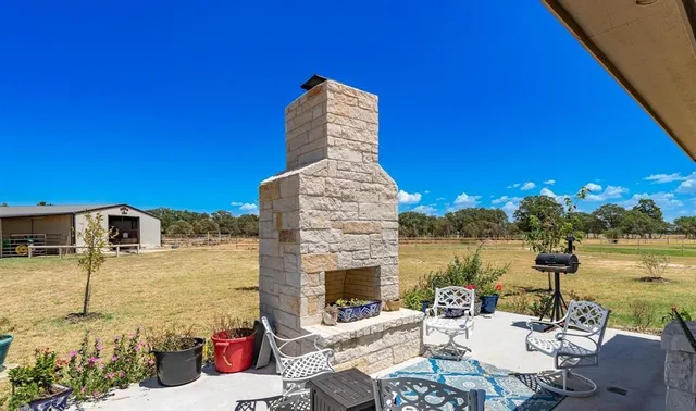 a view of a patio with couches table and chairs under an umbrella
