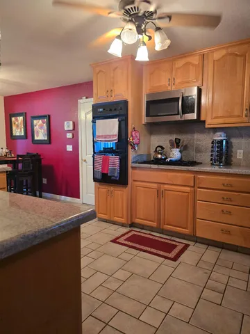 a kitchen with stainless steel appliances granite countertop a sink a stove top oven a granite counter space and cabinets